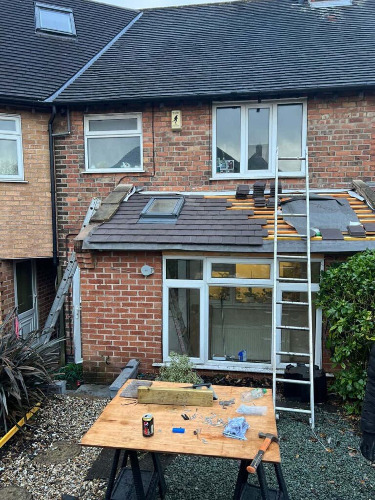 This is a photo of a roof extension that is having new roof tiles installed. This is a photo taken from the roof ridge looking down a tiled pitched roof on to a flat roof. Works carried out by Long Eaton Roofing Repairs