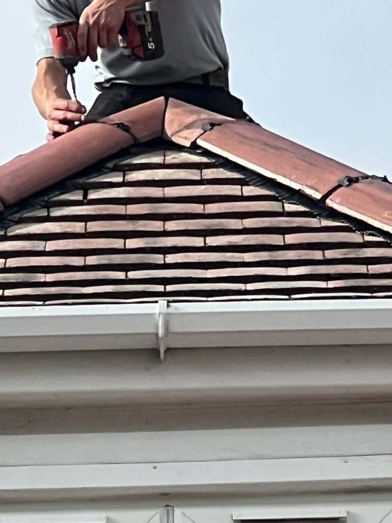 This is a photo of one of the operatives of Long Eaton Roofing Repairs installing new ridge tiles